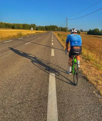 a man riding a bike down a road at La Terrasse - Entire townhouse in hilltop village in Saint-Martin-de-Castillon