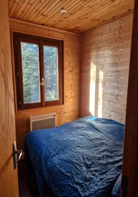 a bedroom with a bed in a wooden cabin at Chalet du Mont Ventoux - Rendez-vous en Provence in Bédoin