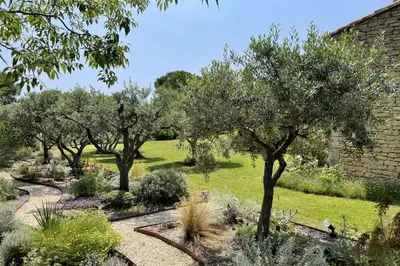 a garden with trees and grass and a building at Mas des Papillons Gordes in Gordes