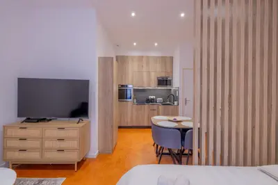 a room with a bedroom with a table and a television at Appartement de Charme in Aix-en-Provence