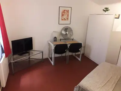 a room with a desk with two chairs and a television at Studio, Aix centre historique in Aix-en-Provence