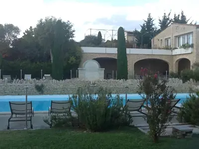 a resort with a pool and chairs and a building at Gordes Le Bastidon in Gordes