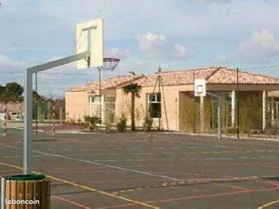 an empty parking lot with a basketball hoop in front of a building at Maison de vacances Aubignan in Aubignan