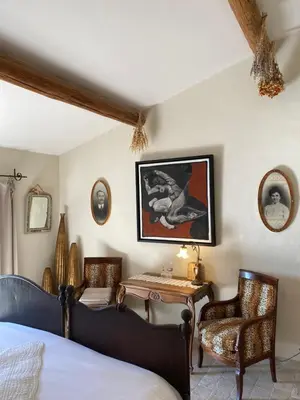 a bedroom with a bed and a table and chairs at Mas de la Beaume in Gordes