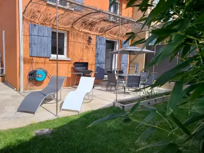 a patio with a table and chairs and an umbrella at Le temps d'une pause in Villes-sur-Auzon
