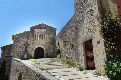 an old stone building with a gate and a door at plein coeur de BANON in Banon