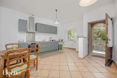 a kitchen with a table and a dining room at Maison Alena Lourmarin Main Square in Lourmarin