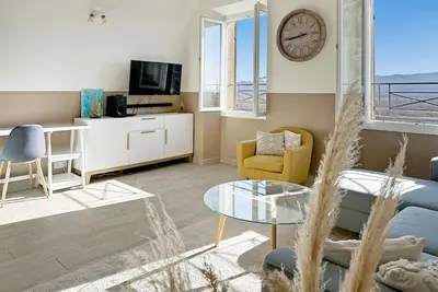 a living room with a couch and a clock on the wall at Les Terrasses du Château I Electio in Lauris