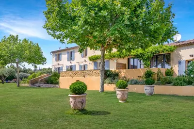 a large house with a tree in the yard at Appartement I Bastide La Gravière I Electio in Lourmarin