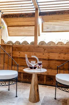 a table with two chairs and two glasses on it at Aux Heures Bleues in LʼIsle-sur-la-Sorgue