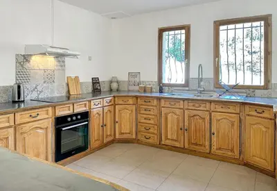 a kitchen with wooden cabinets and a stove top oven at Villa Edelweiss in Lauris
