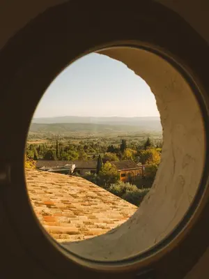 a view from a round window of a stone road at Le Saint Hubert in Saint-Saturnin-les-Apt