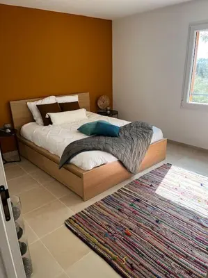 a bedroom with a bed with a rug in it at La villa Rosa in Bédoin