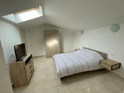 a bedroom with a bed and a flat screen tv at Appartement en campagne avec jardin et piscine in Grans
