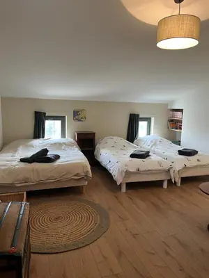 a bedroom with two beds and a rug at La Grange de Paulette in Bédoin