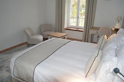 a bedroom with a large white bed and two chairs at Le Domaine d'Euphony in Monteux