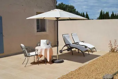 a table and chairs under an umbrella on a patio at Le Domaine d'Euphony in Monteux