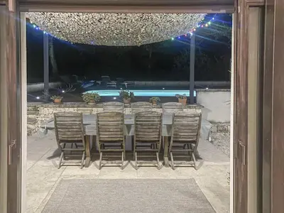 a table and chairs sitting on a patio with a pool at Le Jardin des Chenes in Eyragues