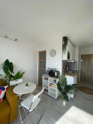a living room with a table and a kitchen at Charmant Studio à 5 min d’Aix en Provence in Aix-en-Provence