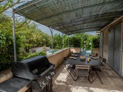 a grill and a table on a patio at La Cadeline in Saumane-de-Vaucluse