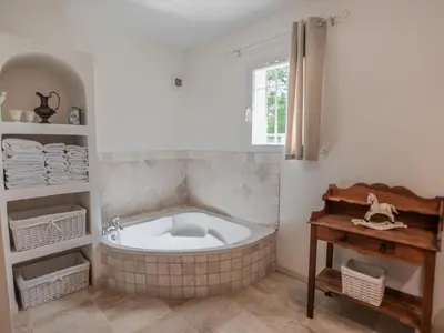 a bath tub in a bathroom with a window at La Cadeline in Saumane-de-Vaucluse