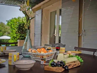 a table with a basket of fruit and a vase of flowers at La Cadeline in Saumane-de-Vaucluse