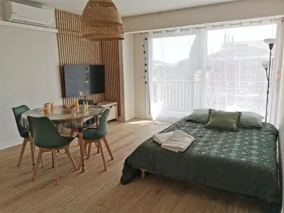 a bedroom with a bed and a table with chairs at Appart'Cosy - clim - terrasse - ascenseur in Cavaillon