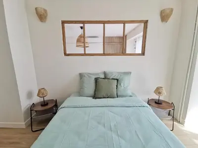 a bedroom with a blue bed and a mirror at Appart'Cosy - clim - terrasse - ascenseur in Cavaillon