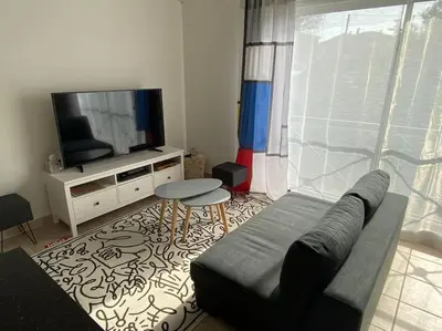 a living room with a couch and a tv at Beau Duplex climatisé T3 vue panoramique Luberon in Pertuis