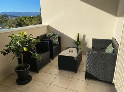 a balcony with chairs and a table and a window at Beau Duplex climatisé T3 vue panoramique Luberon in Pertuis