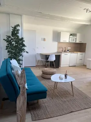 a living room with a blue couch and a table at Spacieux studio 2 à 3 personnes au pied du Ventoux km Zéro in Bédoin