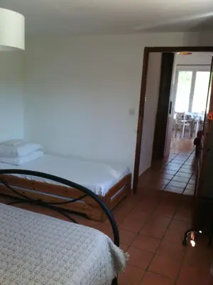a bedroom with a bed and a door to a patio at Le Pas des Lanciers in Mallemort