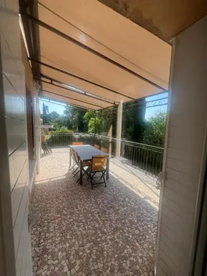 a patio with a table and a view of a balcony at la grande villa in Aix-en-Provence