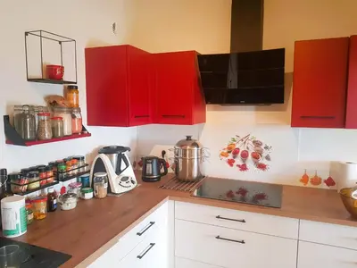 a kitchen with red cabinets and a counter top at Chambre dans Petit havre de paix avec piscine chauffée au coeur du Luberon in Gargas