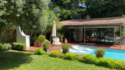 a backyard with a swimming pool and an umbrella at Maison AdriAnna in Vedène