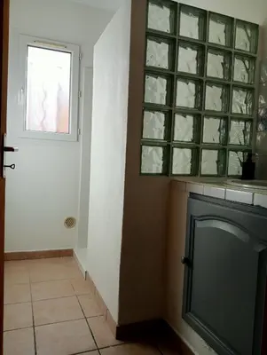 a room with a fireplace and a window and a door at Gîte PITCHOU au pied du VENTOUX in Flassan