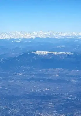 an aerial view of snow capped mountains from an airplane at Gîte PITCHOU au pied du VENTOUX in Flassan