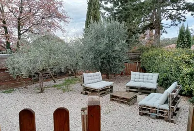 a garden with two chairs and a bench and trees at Gîte PITCHOU au pied du VENTOUX in Flassan