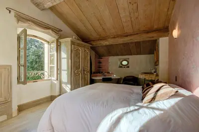 a bedroom with a large bed and a window at Villa élégante à Lambesc avec spa in Lambesc