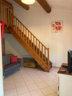 a living room with a staircase and a chair at Maison au Colorado Provençal in Rustrel