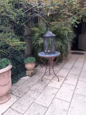 a table with a lantern sitting on a patio at Gite Bienvenue Lili in Châteauneuf-de-Gadagne