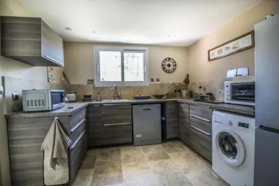 a kitchen with a washer and a sink and a dishwasher at Le charme de Landra in Pernes-les-Fontaines