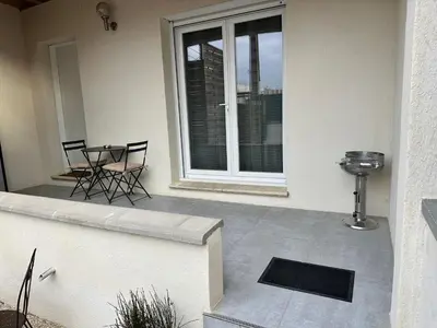 a patio with chairs and a table and a window at Appartement cosy avec cour privée & terrasse Calme idéal couples familles in Cavaillon