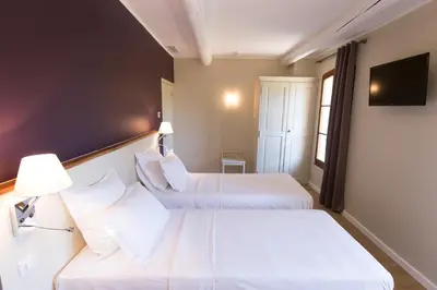 a hotel room with two beds and a tv at Domaine Gao in Aix-en-Provence
