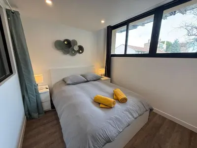 a bedroom with a bed with two yellow objects on it at L'Amandier - Joli appartement T3 neuf centre ville à 2 pas de la Rotonde Mirabeau et des Allées Provençales in Aix-en-Provence