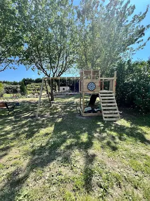 a child sitting on a swing in a yard at La provence avec piscine privative en campagne in Pernes-les-Fontaines