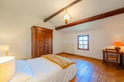 a bedroom with a bed and a desk and a window at La Maison de Sophie in Châteauneuf-de-Gadagne