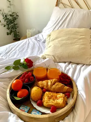 a tray of breakfast food on a bed with orange juice at Provensa - love room avec balneo et terrasse avec vue in Pertuis