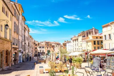 a city street with buildings and people walking down a street at Provensa - love room avec balneo et terrasse avec vue in Pertuis