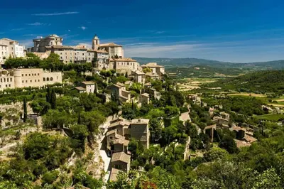 a village on a hill with houses and trees at Provensa - love room avec balneo et terrasse avec vue in Pertuis